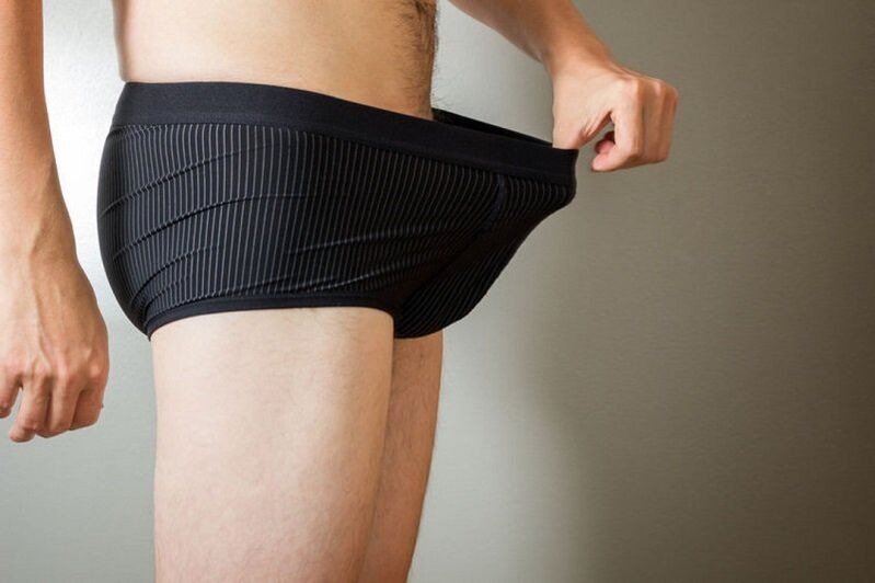 A man looks down at his pants and wants to use soda to enlarge his penis